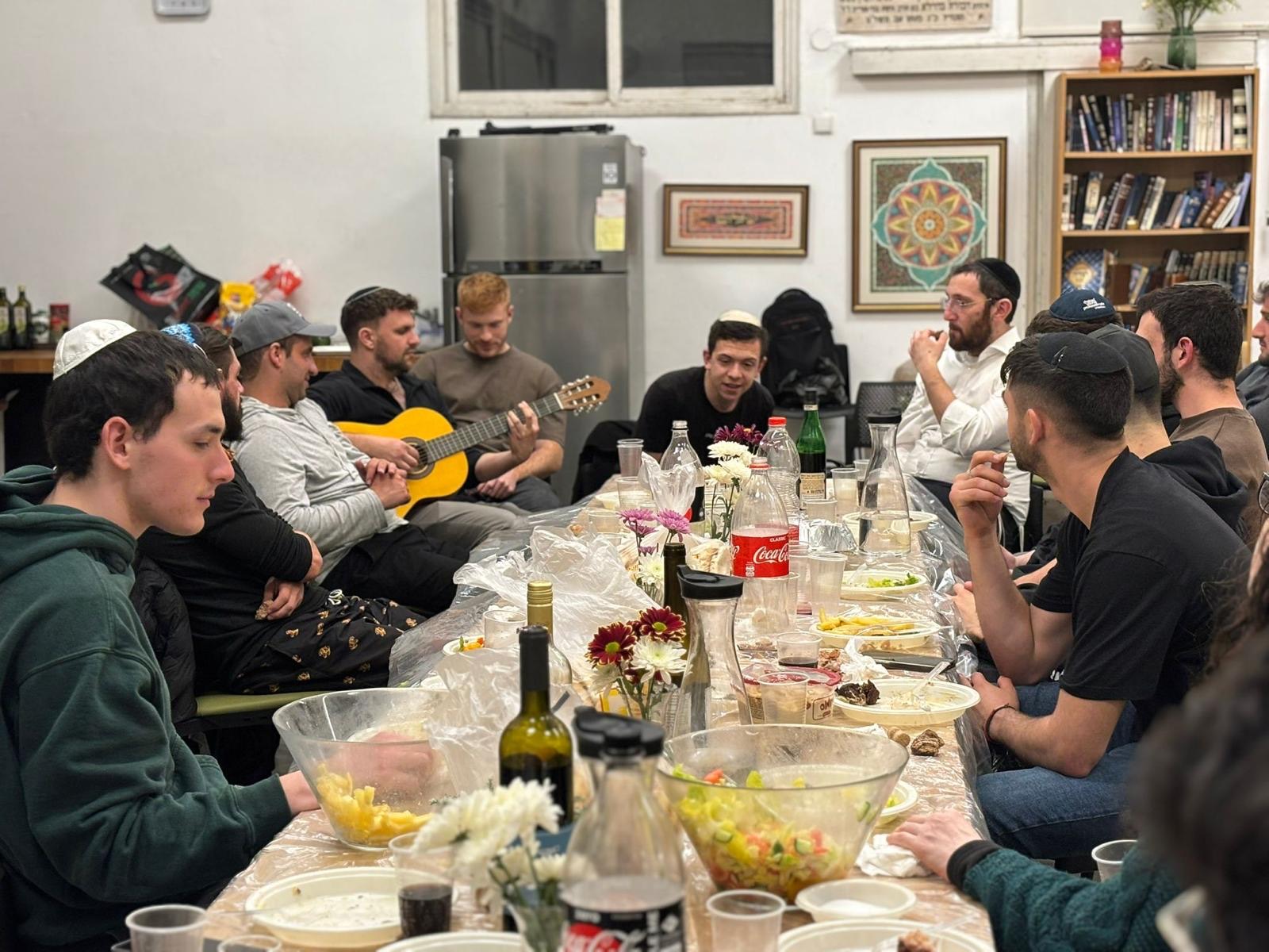 Shabbat dinner with a guitar around a long table at La Casa